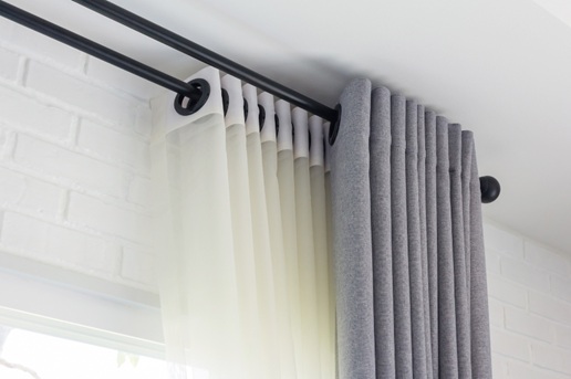 Bright window with fabric curtains and blinds