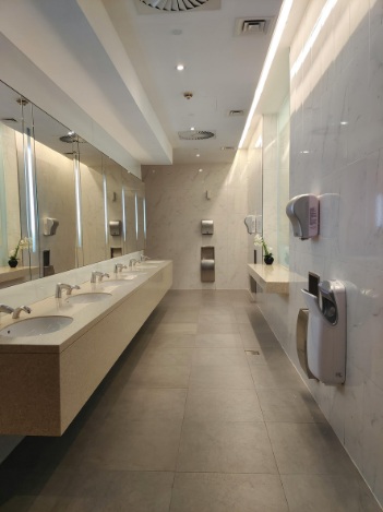 Commercial cleaning services equipment operated by a professional cleaner inside an office corridor.